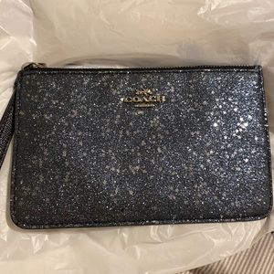 navy Coach wristlet with silver detailing.
